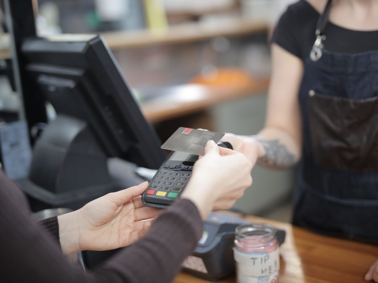 A customer paying by card at a café counter