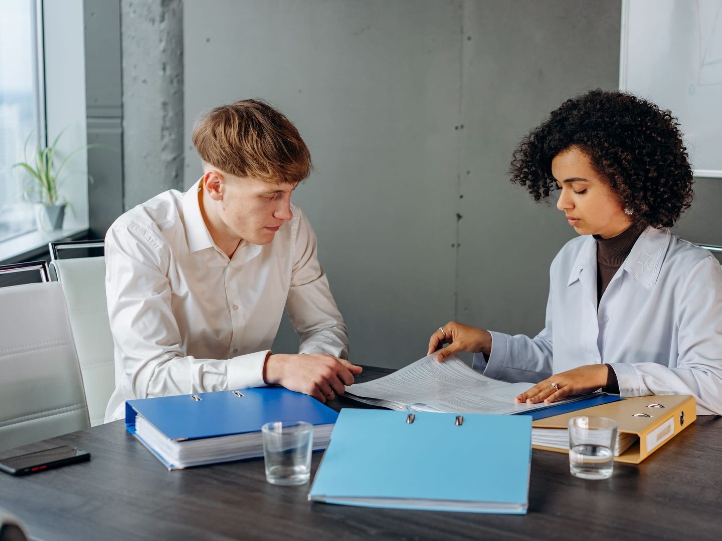 An auditor working through compliance binders